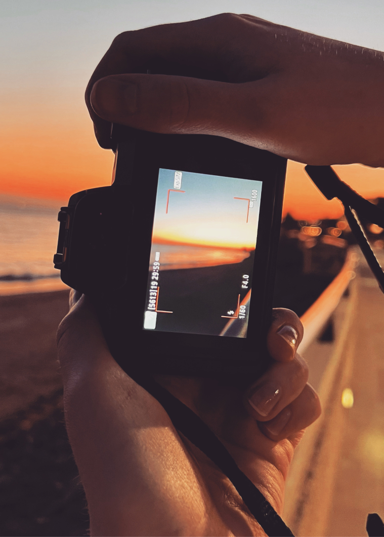Camera held against a glowing sunset