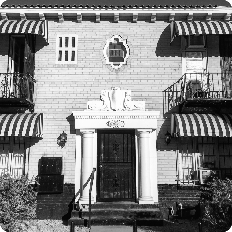Black and white architectural study of a striped-awning facade