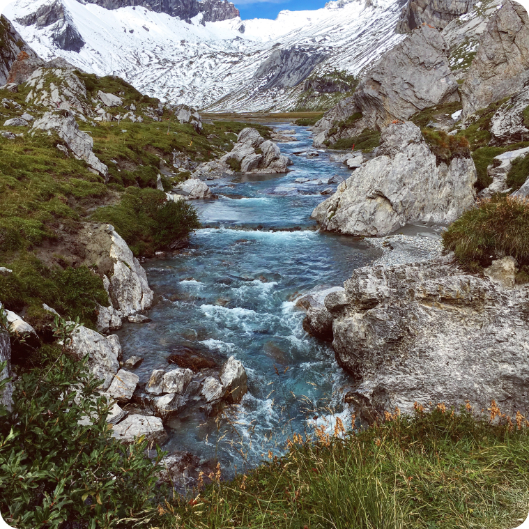 Mountain stream flowing between snow-covered peaks